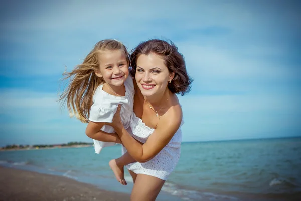 Feliz hermosa madre e hija disfrutando del tiempo de playa — Foto de Stock