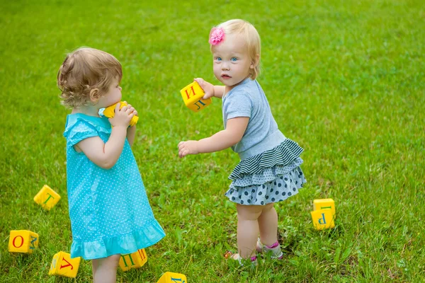 Little girls on nature playing toy — Stock Photo, Image