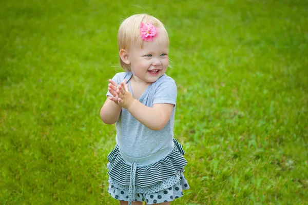 Little girl on background grass — Stock Photo, Image