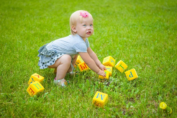 Little girl on nature playing toy — Stock Photo, Image