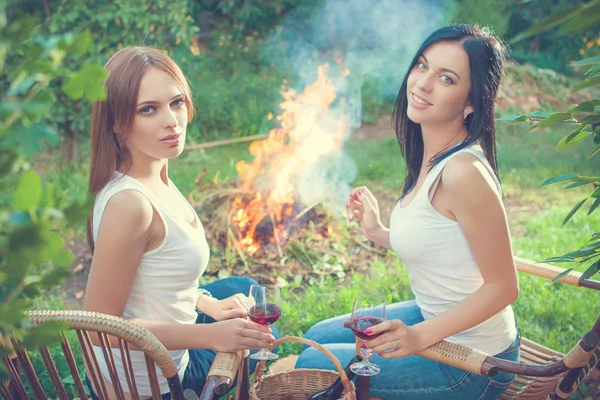 Chicas con copas de vino tinto cerca de la hoguera — Foto de Stock