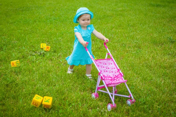 Niña en la naturaleza con carro de bebé — Foto de Stock