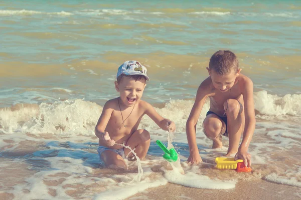 Glückliche Kinder - zwei Jungen, die sich am Strand vergnügen — Stockfoto