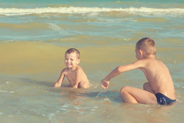 Glückliche Kinder - zwei Jungen, die sich am Strand vergnügen Stockfoto