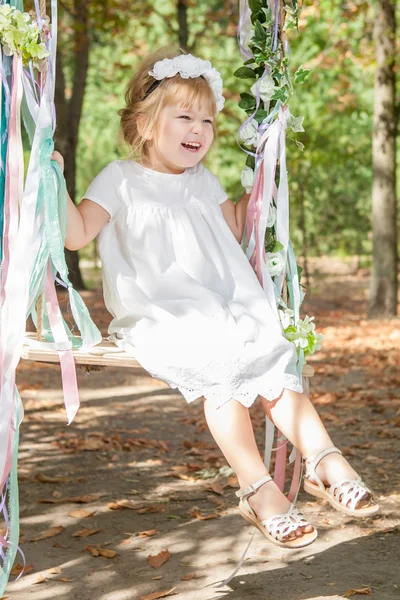 Happy little girl on a swing — Stock Photo, Image