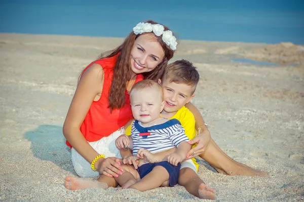 Mamma och hennes två söner att ha kul på stranden — Stockfoto