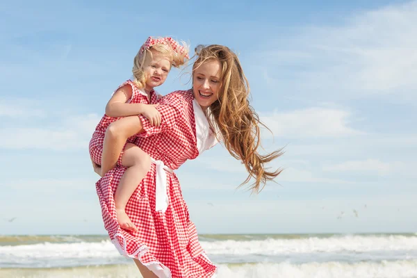 Madre e hija divirtiéndose jugando en la playa — Foto de Stock