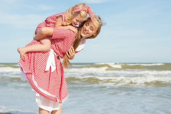 Madre e hija divirtiéndose jugando en la playa — Foto de Stock