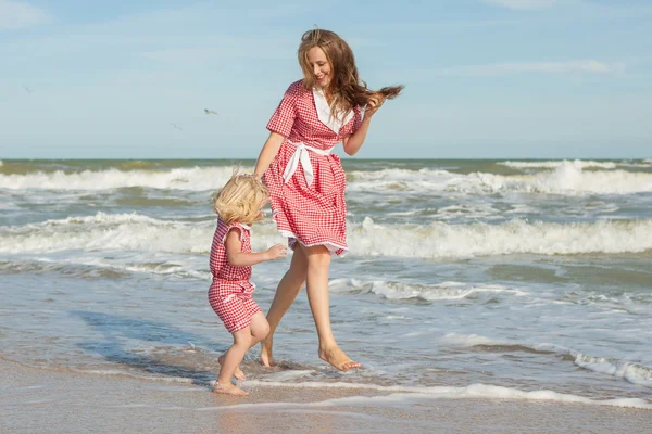 Mãe e filha se divertindo brincando na praia — Fotografia de Stock