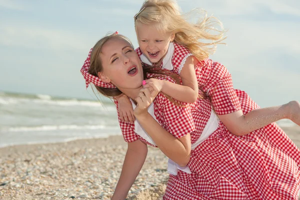 Mother and daughter having fun playing on the beach — Stock Photo, Image