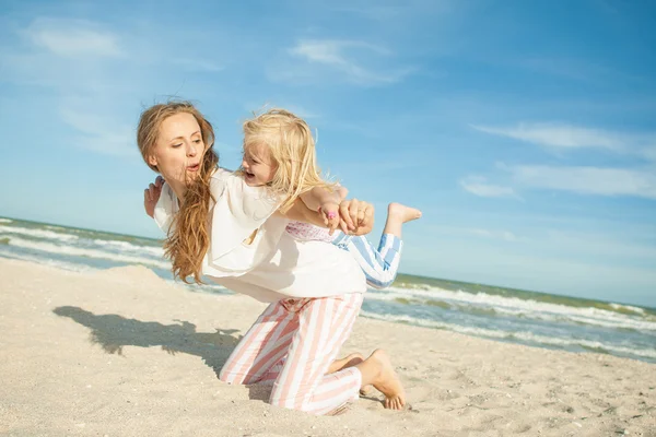 Madre e hija divirtiéndose jugando en la playa — Foto de Stock