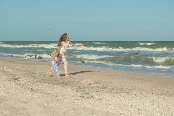 Mãe e filha se divertindo brincando na praia — Fotografia de Stock