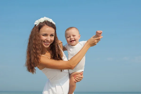 Happy beautiful mother and son enjoying beach time — Stock Photo, Image