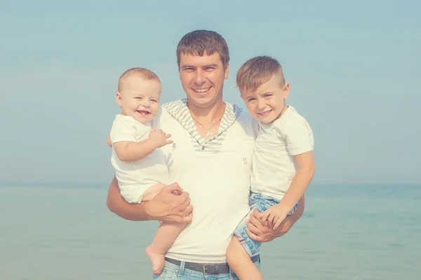 Far och hans söner att ha kul på stranden — Stockfoto