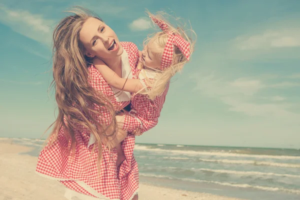 Mor og hendes datter har det sjovt på stranden - Stock-foto