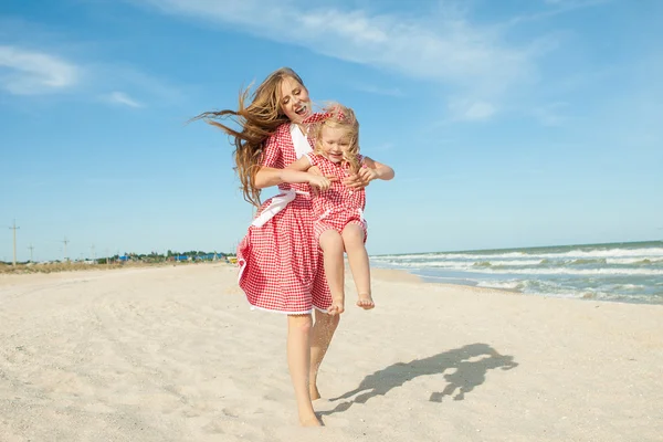 Moeder en haar dochter plezier op het strand — Stockfoto