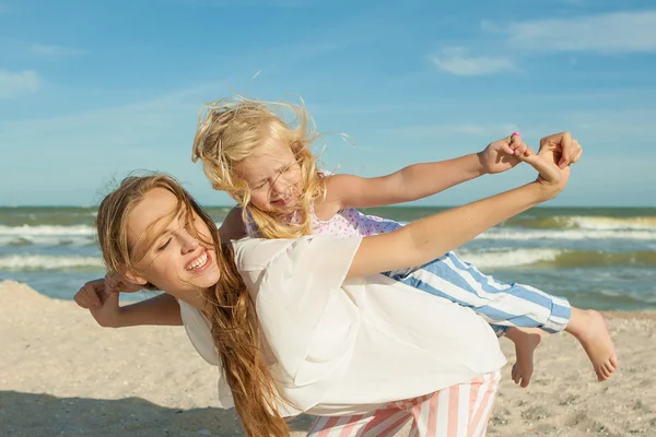 Moeder en haar dochter plezier op het strand — Stockfoto