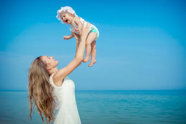 Happy beautiful mother and daughter enjoying beach time — Stock Photo, Image