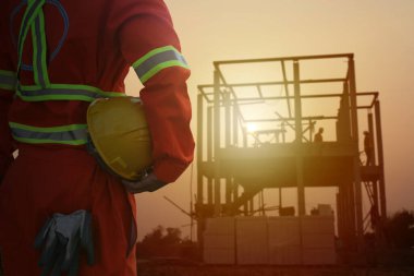 Gün batımında şantiyede çalışan mühendislerin silueti..