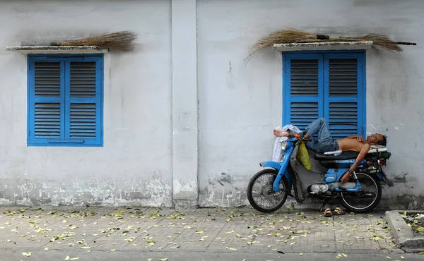Vietnamese motorbike taxi driver sleeping on motorcycle — Stock Photo, Image