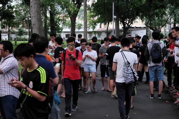 Jonge Aziatische spelen Pokemon gaan op smart phone — Stockfoto