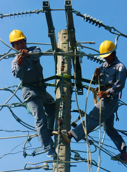 Elettricista asiatico salire in alto, lavorare sul palo elettrico — Foto Stock
