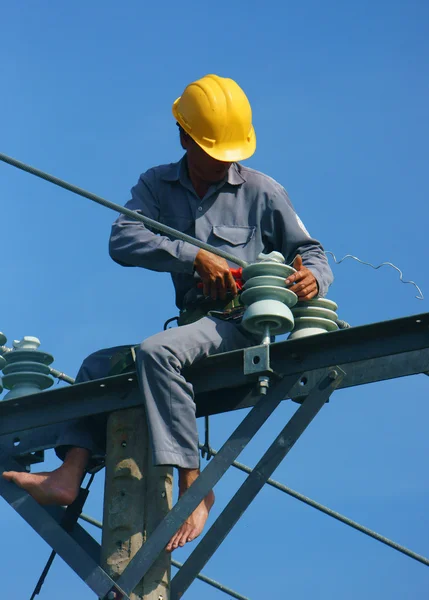 Ázsiai villanyszerelő mászni magas, elektromos pole munka — Stock Fotó