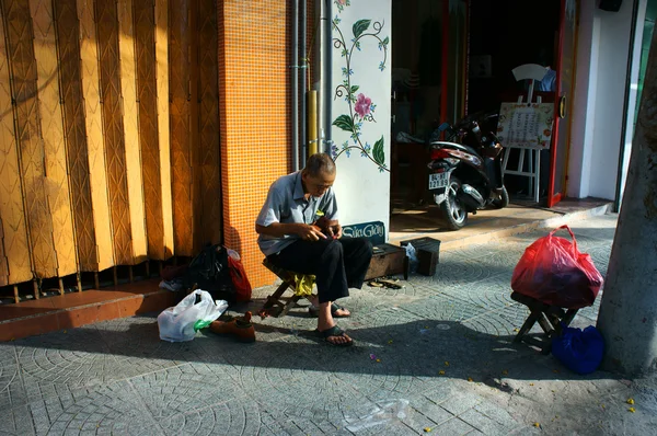 Старший вьетнамский мужчина, ремонтная обувь — стоковое фото