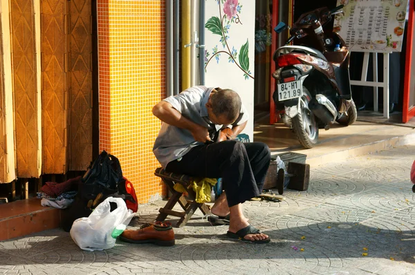 Vezető vietnami férfi, cipő javítás — Stock Fotó