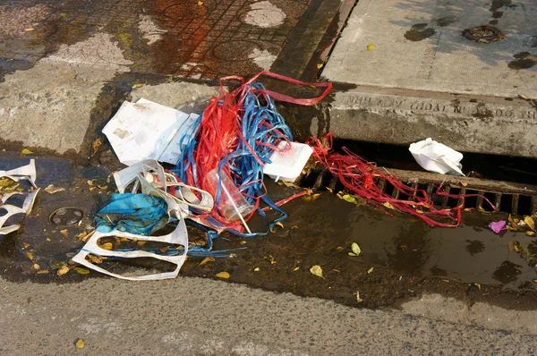 Waste at manhole, polluted city — Stock Photo, Image