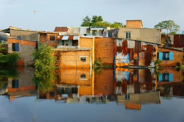 Casa baja de la orilla del río, pared de ladrillo, pobres — Foto de Stock