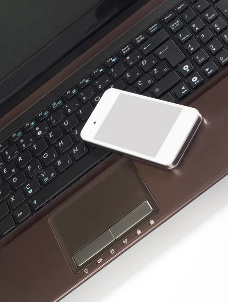 Inteligentny telefon na laptopie — Zdjęcie stockowe