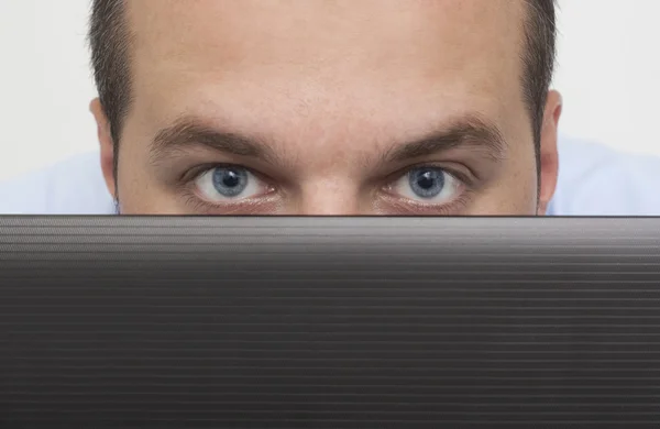 Hombre espiando sobre el ordenador portátil — Foto de Stock