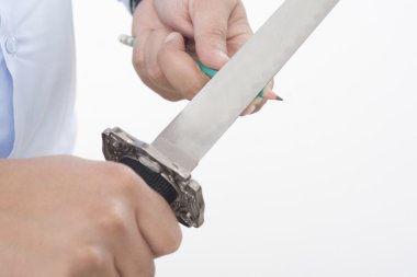 bir kılıç ile kalemler keskinleştirme