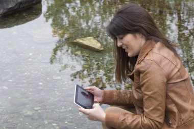 suya yakın bir dijital tablet kullanan kız