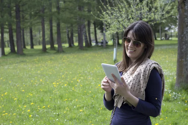 Ținând o tabletă digitală în parc — Fotografie, imagine de stoc