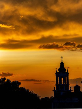 Kilisenin üzerindeki bulutlarla dramatik günbatımı