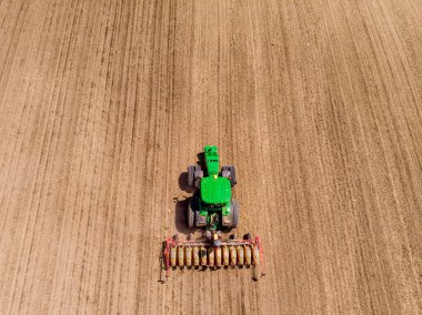 Bir traktör baharda ekin eker.