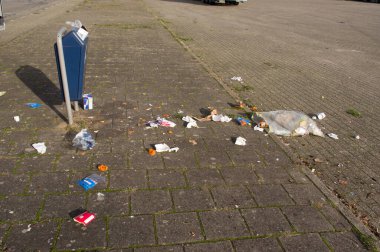 Arnhem, Hollanda - 7 Kasım 2020: Sokaktaki kirlilik bir çöp konteynırının yanında.