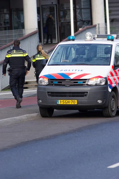Nijmegen, Hollanda - 14 Ocak 2020: Hollanda polis memurları polis arabasından iniyor