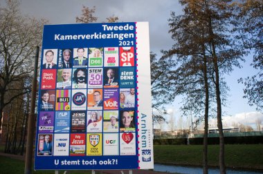Arnhem, Netherlands - February 26: Billboard with dutch political campaign posters for the Dutch House of Representatives elections in march 2021. clipart