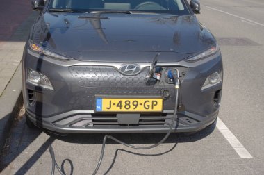 Arnhem, Netherlands - April 16, 2021: Electric car connected to charge station for charging the battery