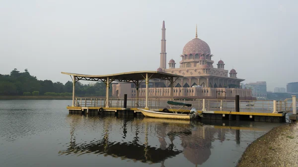 Steg und Boot mit Putrajaya-Moschee im Morgennebel — Stockfoto