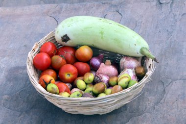 Taş zemine bırakılmış taze sebze sepeti.