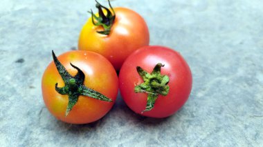 Taş zeminde izole edilmiş taze kırmızı domates.