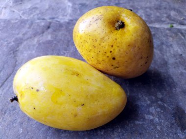 Taze, sağlıklı sarı mango taştan arka planda izole edilmiş.