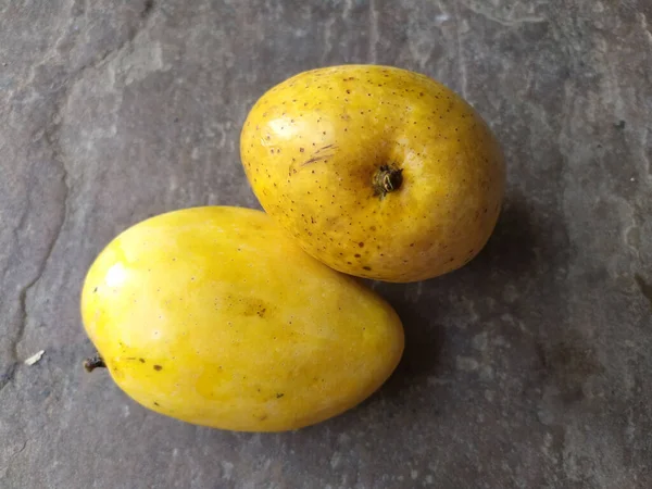 石の背景に閉じ込められた新鮮な健康的な黄色のマンゴー — ストック写真