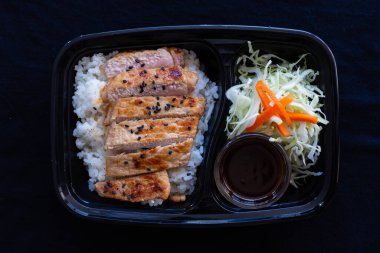 Butadon, siyah arka planda pilavlı ızgara domuz eti..