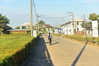 Rayong, Tayland 20 Mayıs 2018 'de köy yolunda bisiklet süren bir bayan..