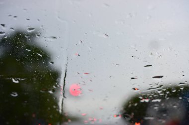 Arka plandaki araba camlarına su damlıyor.